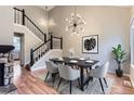 A beautifully staged dining room boasts modern lighting, a sleek table setting, and a view of the staircase at 19481 E Milan Cir, Aurora, CO 80013