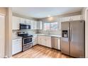 Bright kitchen featuring stainless steel appliances, white cabinets, and sleek countertops at 19481 E Milan Cir, Aurora, CO 80013