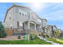 Two-story townhome with gray siding, brown accents, and a landscaped front yard at 4343 S Nepal Ct, Centennial, CO 80015