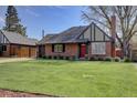 Charming brick home featuring a well-manicured lawn and a pop of color from the red front door at 782 Holly St, Denver, CO 80220