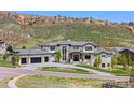 Beautiful exterior of a modern home with a three-car garage, set against a scenic mountain backdrop at 15191 Dinosaur Ridge Rd, Morrison, CO 80465