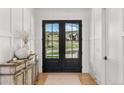 Inviting foyer with double glass doors offering scenic views and a rustic console table at 15191 Dinosaur Ridge Rd, Morrison, CO 80465