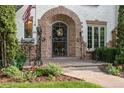 Inviting front entrance with brick archway, decorative iron gate, and well-maintained garden at 5530 E 6Th Ave Pkwy, Denver, CO 80220