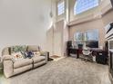 Bright living room featuring large windows, neutral carpet, a comfortable sofa, and a dedicated office space at 9832 Kenton Cir, Commerce City, CO 80022