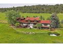 Scenic backyard view showcasing a well-kept lawn, stone retaining wall, and a deck, perfect for outdoor enjoyment at 5939 Lone Peak Dr, Evergreen, CO 80439
