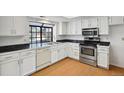 Well-lit kitchen featuring white cabinets, stainless steel appliances, and a stylish countertop at 12622 E Warren Dr # E, Aurora, CO 80014