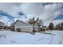 Wide angle view of a two-story home's side and garage in winter at 9309 W 87Th Pl, Arvada, CO 80005