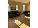 Inviting living room with modern floors, bright windows and comfortable leather sofa and chair at 7414 E 28Th Ave # 4, Denver, CO 80238