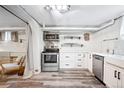 Modern kitchen featuring stainless steel appliances, white cabinets, and stylish wood-look flooring at 1331 N Ogden St # 1, Denver, CO 80218