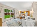 Open-concept living room seamlessly connects to the kitchen with a large sliding glass door to the backyard at 12545 Elm St, Thornton, CO 80241