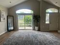 Open concept living room with large windows, vaulted ceilings, and light wood flooring at 14400 Albrook Dr # 88, Denver, CO 80239