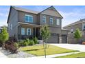 Lovely two-story home featuring a covered front porch, 3 car garage and manicured lawn at 13962 Shasta Daisy St, Parker, CO 80134