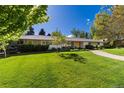 Well-maintained single-story home with lush green lawn, mature trees, and a welcoming walkway at 3925 S Cherry St, Englewood, CO 80113