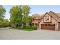 Stately home with manicured landscaping, an attached garage, and a circular driveway at 6616 E Prentice Ave, Greenwood Village, CO 80111