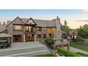 Beautiful brick home with stone accents, a stone chimney, and a well-manicured lawn at 6616 E Prentice Ave, Greenwood Village, CO 80111