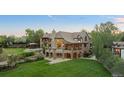 Expansive home features a lush lawn, stone accents, and a charming gazebo at 6616 E Prentice Ave, Greenwood Village, CO 80111