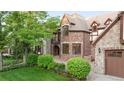 Beautifully landscaped home featuring lush greenery, brick accents, and a multi-car garage at 6616 E Prentice Ave, Greenwood Village, CO 80111