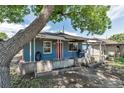 Charming brick home featuring a covered porch, red front door, and landscaped features at 3151 N Elizabeth St, Denver, CO 80205