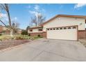 Side view of a home with a brick facade, an attached two-car garage, and a driveway at 9698 Pecos St, Thornton, CO 80260