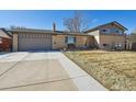 Charming two-story home featuring a long driveway and a classic brick facade at 1300 Kennedy Dr, Northglenn, CO 80234