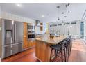Modern kitchen boasts stainless steel appliances, center island with seating, and sleek wood cabinetry at 1620 Little Raven St # 103, Denver, CO 80202