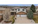 Two story home with a stone accent, three car garage, and professionally landscaped yard at 9249 Fox Fire Dr, Highlands Ranch, CO 80129