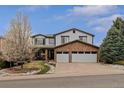 Attractive two-story home with a stone accent facade, two-car garage, and a well-manicured front lawn at 9249 Fox Fire Dr, Highlands Ranch, CO 80129