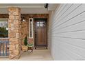 Charming home entrance featuring a beautiful wood door, stone accents, and a welcoming decor at 9249 Fox Fire Dr, Highlands Ranch, CO 80129