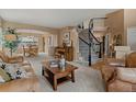 Inviting living room featuring a curved staircase, neutral decor, and a connecting dining area at 9249 Fox Fire Dr, Highlands Ranch, CO 80129