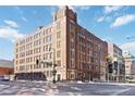 Exterior shot of brick warehouse loft building with street signage, traffic signal, and other buildings nearby at 1863 Wazee St # 6E, Denver, CO 80202