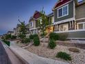 Exterior view of townhouses showing green siding, landscaped front yard, and a sidewalk at 23545 E Platte Dr # C, Aurora, CO 80016