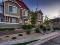 Townhouse exterior featuring green siding, stone accents, and landscaped front yard at 23545 E Platte Dr # C, Aurora, CO 80016