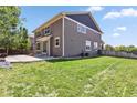 Large backyard with a concrete patio and lush green grass, perfect for outdoor activities at 3823 Horiuchi St, Brighton, CO 80601