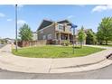 Corner lot home with a well-maintained lawn and street sign at the intersection at 3823 Horiuchi St, Brighton, CO 80601