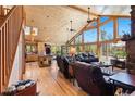 Open living room with wood walls, hardwood floor, and cathedral windows with a view at 14800 Gold Hill Rd, Boulder, CO 80302