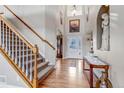 Bright foyer showcasing hardwood floors, a staircase, and elegant front door at 3188 Soaring Eagle Ln, Castle Rock, CO 80109