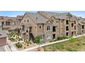 Well-maintained apartment building with stone accents and manicured landscaping at 10062 W Victoria Pl # 205, Littleton, CO 80127