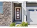 Inviting front entrance with a modern red door and stone accents at 3989 Gold Bug St, Aurora, CO 80019