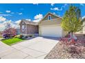 Well-kept home featuring desert landscaping, a paved driveway, and a two-car garage at 12636 Sandstone Dr, Broomfield, CO 80021