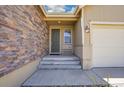 Inviting front porch with stone facade and concrete steps leads to the home's entrance at 12636 Sandstone Dr, Broomfield, CO 80021