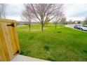 Lush backyard with green grass and mature trees in a serene setting at 17722 E Ida Ave, Centennial, CO 80015