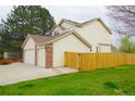 Exterior view of a house with a two-car garage and a fenced backyard at 17722 E Ida Ave, Centennial, CO 80015