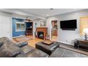 Open concept living room with hardwood floors, fireplace, and blue accent wall at 2680 S Garfield Cir, Denver, CO 80210