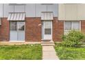 Townhouse brick entry with decorative door and awning provides curb appeal and charm at 8613 Santa Fe Dr, Thornton, CO 80260