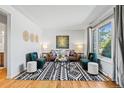 Bright living room featuring a modern rug, stylish seating, and large window, creating a welcoming space at 5920 Garrison St, Arvada, CO 80004