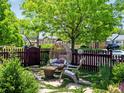 Inviting outdoor seating area with unique egg chair, garden, stepping stones, and picket fence at 3580 Krameria St, Denver, CO 80207