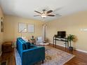 Inviting living room featuring a blue velvet sofa, ceiling fan, modern art, and hardwood floors at 3580 Krameria St, Denver, CO 80207