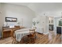 Charming dining area with a table set for four, a piano, and wood-look flooring at 5102 S Lisbon Way, Centennial, CO 80015