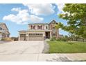 Gorgeous two-story home with a three-car garage, stone detailing, and a well-maintained lawn at 16881 E 110Th Ave, Commerce City, CO 80022