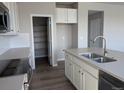 Close-up of the kitchen featuring white cabinets, stainless appliances, and a pantry at 16815 Mckay Dr, Mead, CO 80542